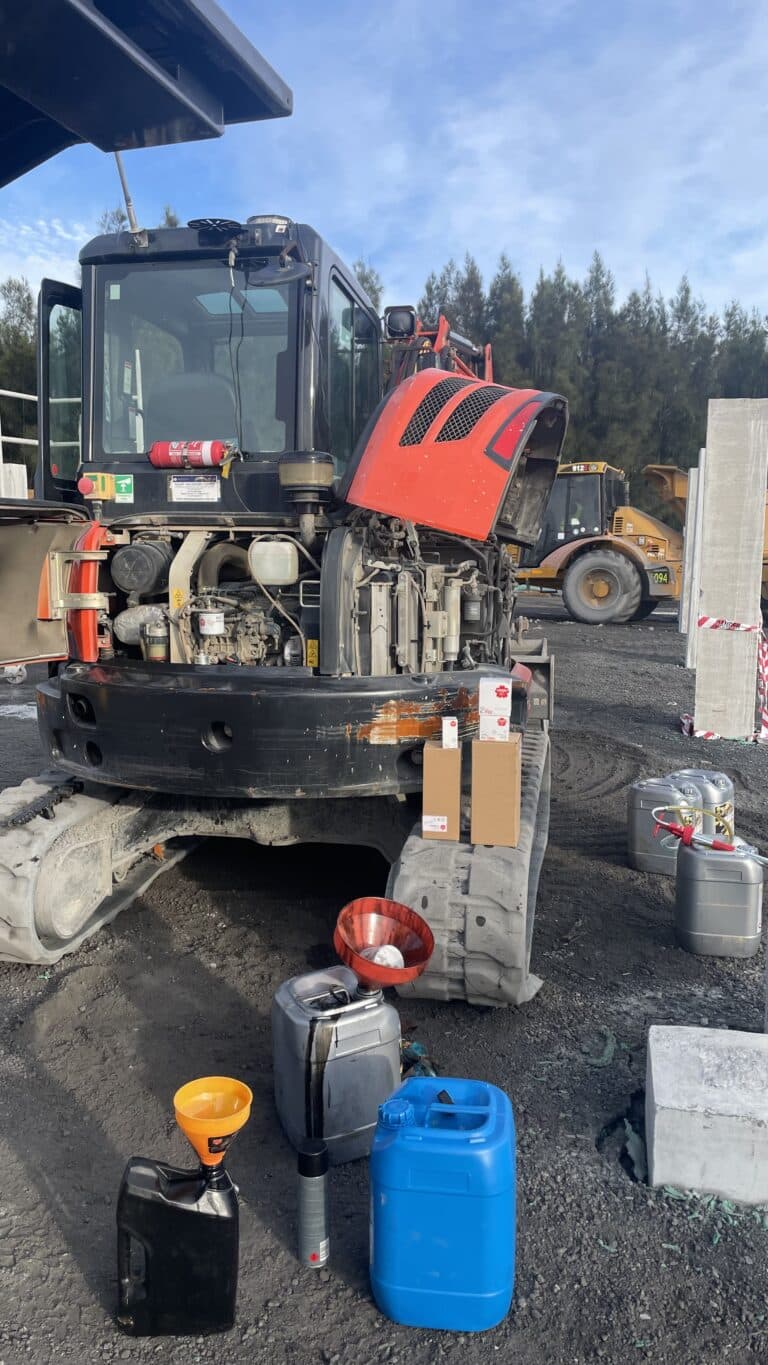 Excavator with open engine bay during onsite maintenance